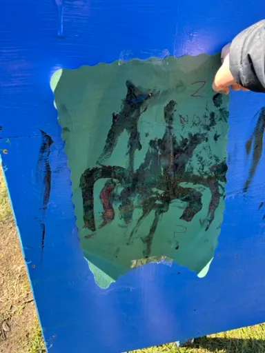 A tamaiti proudly holding up their painting