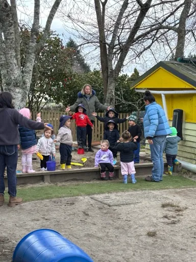 Tamariki digging and building together in the sandpit